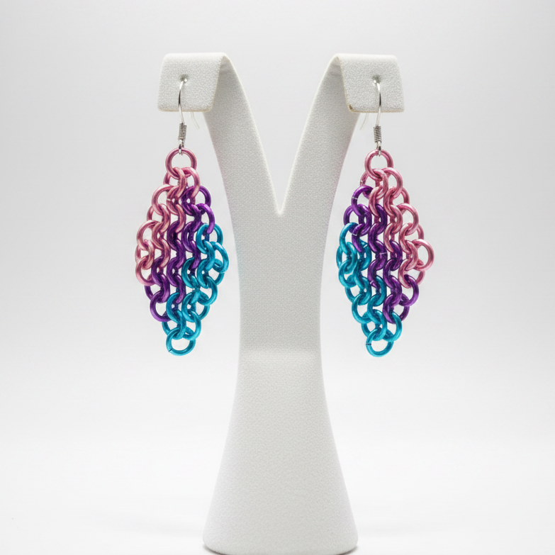Chainmail earrings on display stand with light background