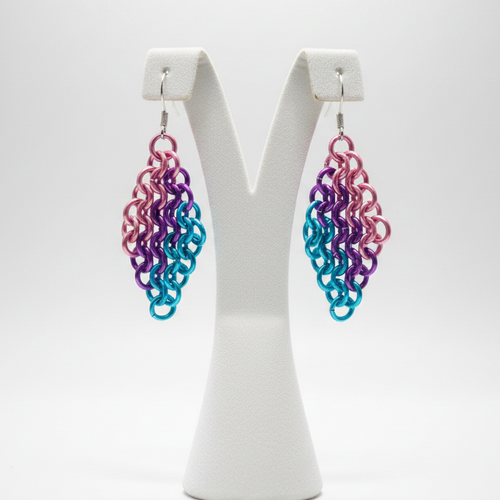 Chainmail earrings on display stand with light background