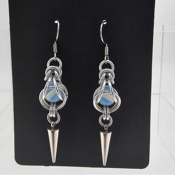 Pair of silver aluminum earrings with opalite white captured bead and stainless steel spike